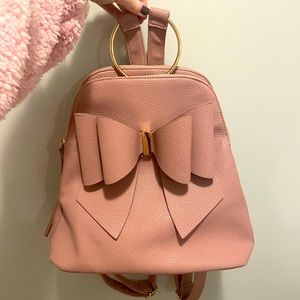 Dusty pink backpack style purse with bow.